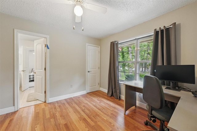 office area featuring baseboards, a textured ceiling, ceiling fan, and light wood-type flooring