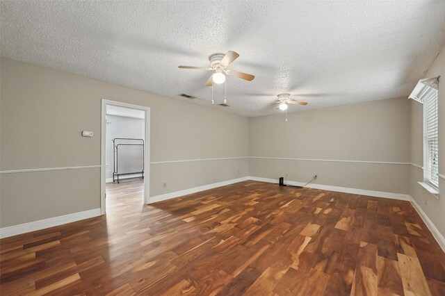 unfurnished room with a textured ceiling, ceiling fan, baseboards, and wood finished floors