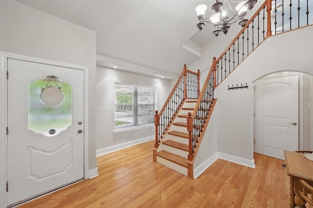 entrance foyer featuring arched walkways, baseboards, and stairs