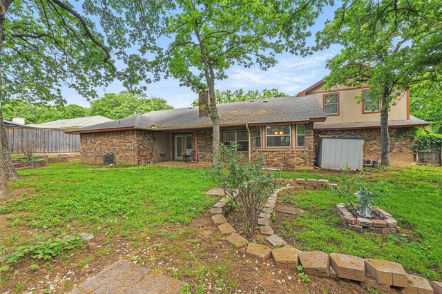 5608 Trail Lake Dr, Arlington, TX 76016 - back of property with an outdoor fire pit and brick siding