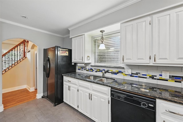 kitchen with ornamental molding, arched walkways, a sink, backsplash, and black appliances