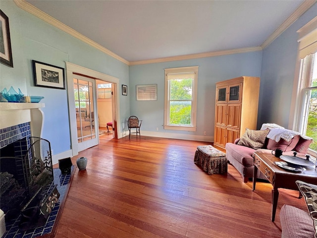 900 Park Dr, Hillsboro, TX 76645 - interior space featuring a tiled fireplace, ornamental molding, wood finished floors, and a wealth of natural light