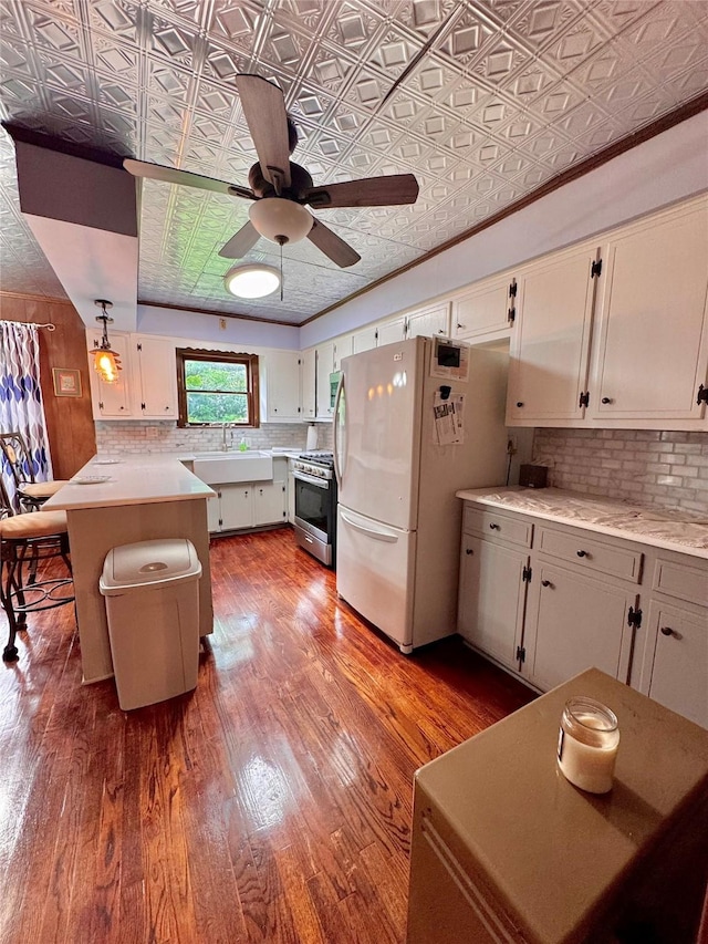 900 Park Dr, Hillsboro, TX 76645 - kitchen featuring gas stove, an ornate ceiling, freestanding refrigerator, a peninsula, and tasteful backsplash