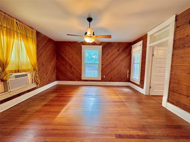 900 Park Dr, Hillsboro, TX 76645 - unfurnished room with baseboards, ceiling fan, wood walls, and wood finished floors