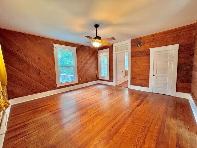 900 Park Dr, Hillsboro, TX 76645 - spare room with a ceiling fan, baseboards, wood walls, and light wood finished floors