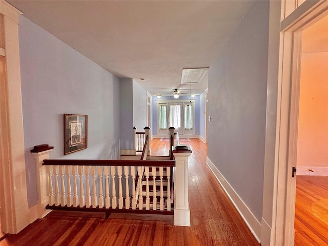 900 Park Dr, Hillsboro, TX 76645 - corridor with baseboards, attic access, wood finished floors, and an upstairs landing