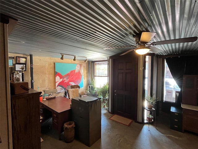 office space with track lighting, ceiling fan, and concrete floors