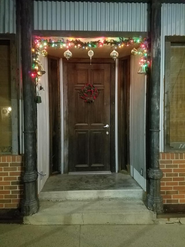 doorway to property featuring brick siding