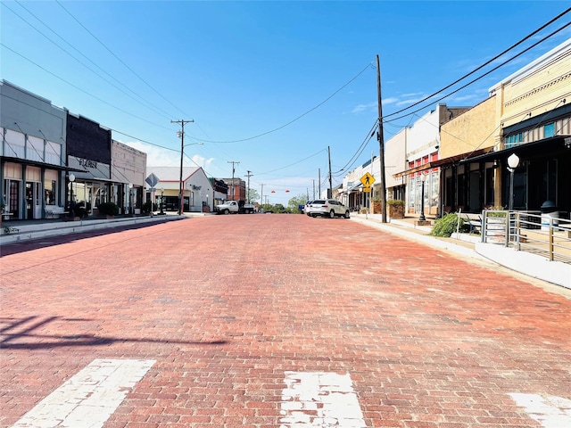 view of road with curbs, a residential view, sidewalks, street lights, and traffic signs