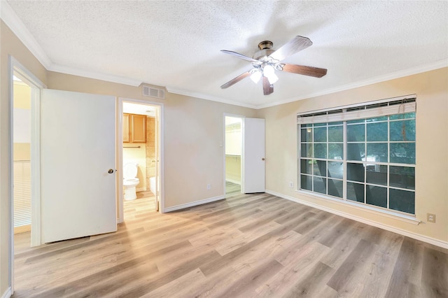 empty room featuring ceiling fan, light wood-type flooring, a textured ceiling, and visible vents