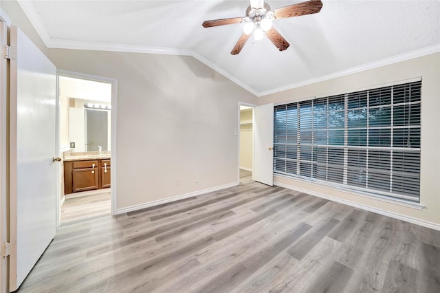 spare room with crown molding, ceiling fan, light wood-style flooring, and lofted ceiling