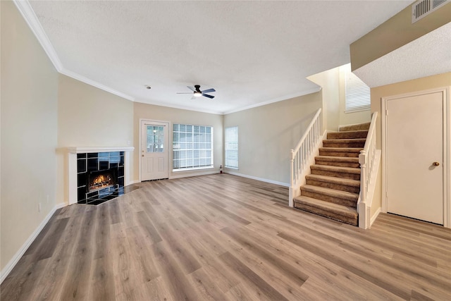 unfurnished living room with visible vents, stairs, ceiling fan, and wood finished floors