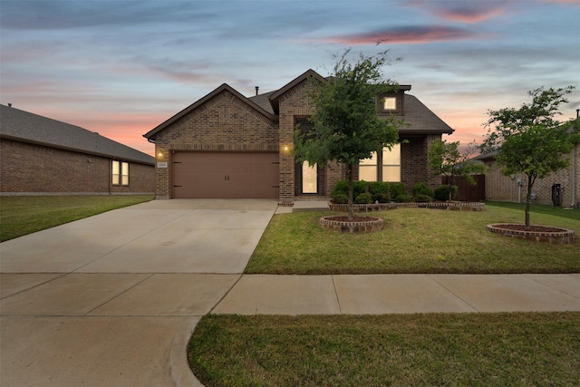 view of front of home featuring a garage, a yard, concrete driveway, and brick siding