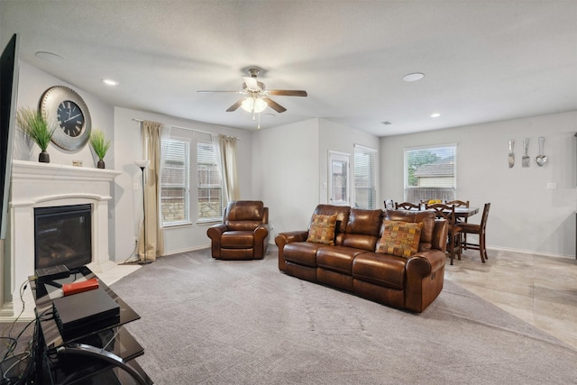 living room with a glass covered fireplace, baseboards, ceiling fan, and recessed lighting
