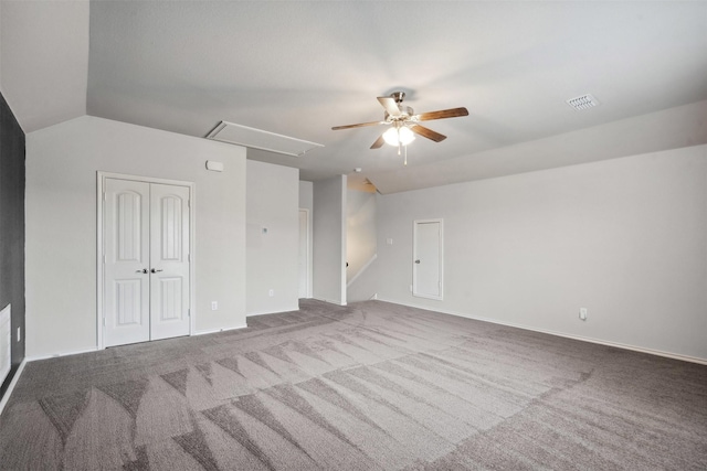 interior space with a ceiling fan, vaulted ceiling, attic access, and visible vents