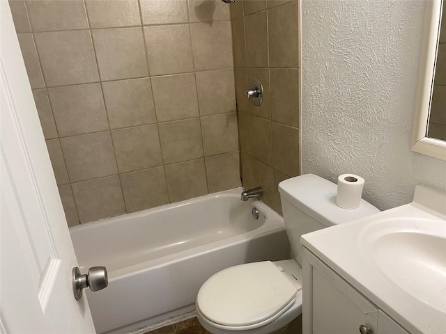 full bath with vanity, toilet, a textured wall, and bathtub / shower combination