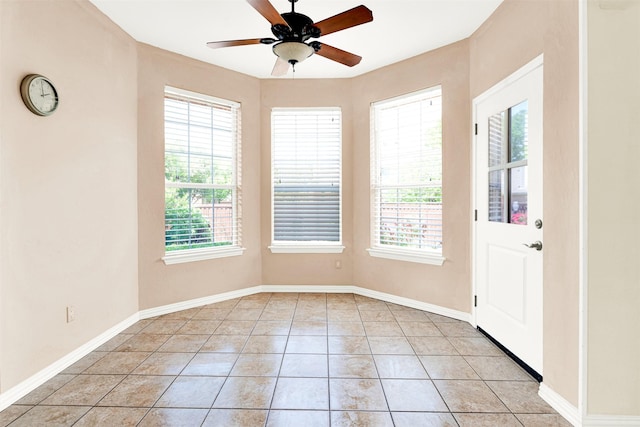 interior space with plenty of natural light, baseboards, ceiling fan, and light tile patterned floors