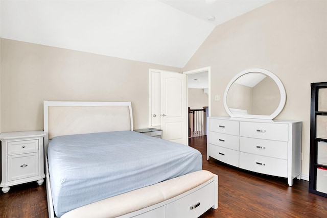bedroom with dark wood finished floors and lofted ceiling