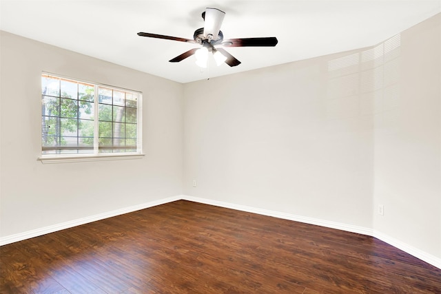 empty room featuring baseboards, a ceiling fan, and dark wood-type flooring