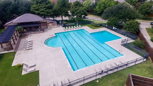 pool featuring a lawn, a patio, and fence