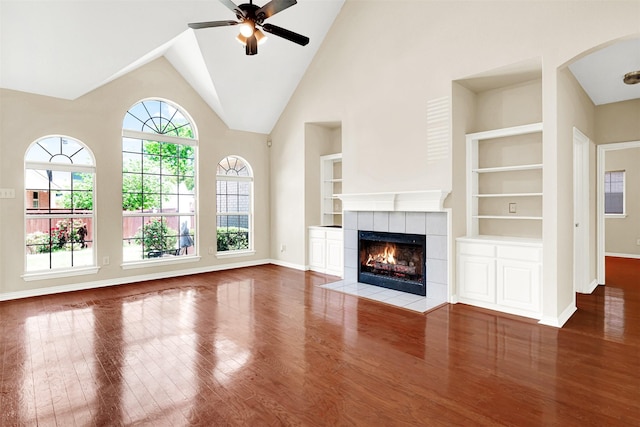 3837 Evesham Dr, Plano, TX 75025 - unfurnished living room featuring built in features, wood finished floors, baseboards, a ceiling fan, and a tiled fireplace
