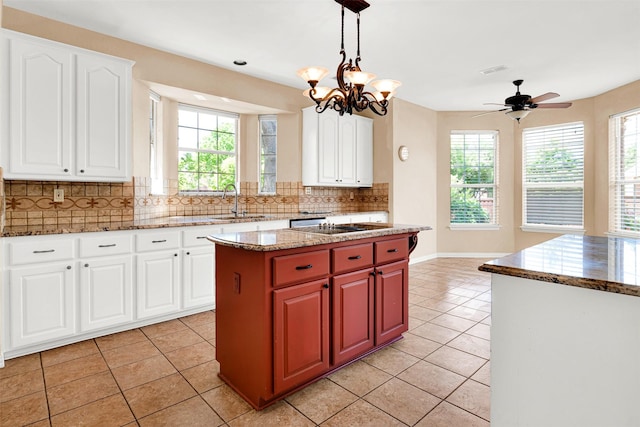 kitchen with light tile patterned floors, decorative backsplash, stone counters, and a sink