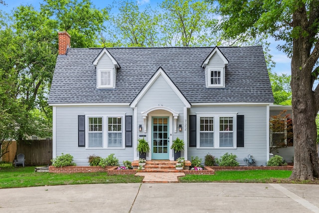 new england style home featuring a shingled roof, fence, and a chimney