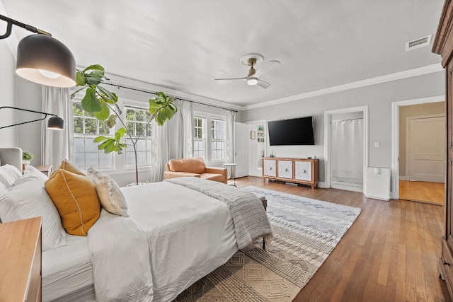 bedroom featuring ornamental molding, hardwood / wood-style flooring, and visible vents