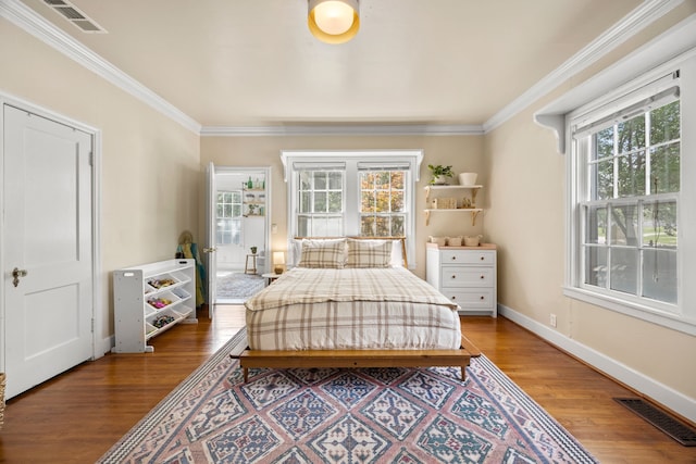 bedroom with crown molding, visible vents, and wood finished floors