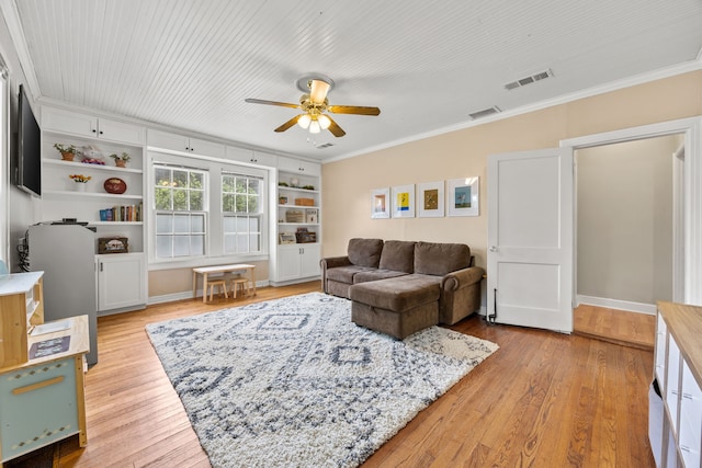 living room featuring ceiling fan, visible vents, ornamental molding, and light wood-type flooring