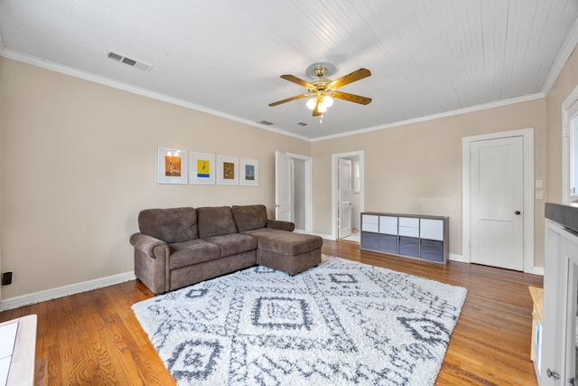 living room with a ceiling fan, baseboards, wood finished floors, visible vents, and ornamental molding