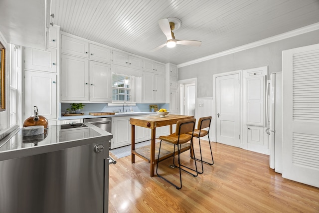 kitchen with white cabinets, freestanding refrigerator, light wood finished floors, and ceiling fan