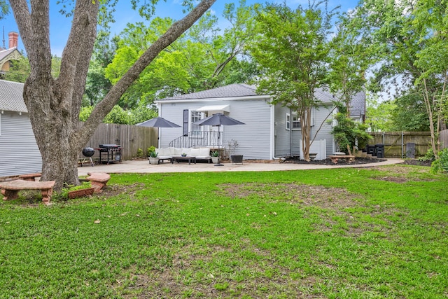 rear view of property featuring a yard, a patio, an outdoor hangout area, and a fenced backyard