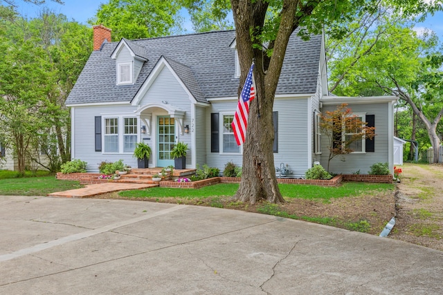 view of front of house featuring roof with shingles and a chimney