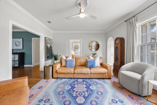 living room with plenty of natural light, ornamental molding, and wood finished floors