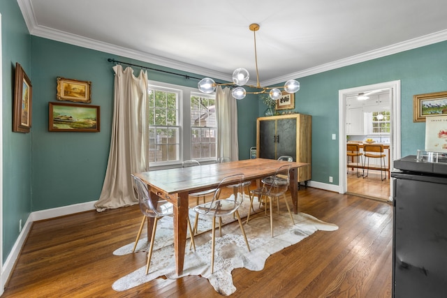 dining area with crown molding, baseboards, and dark wood-style flooring