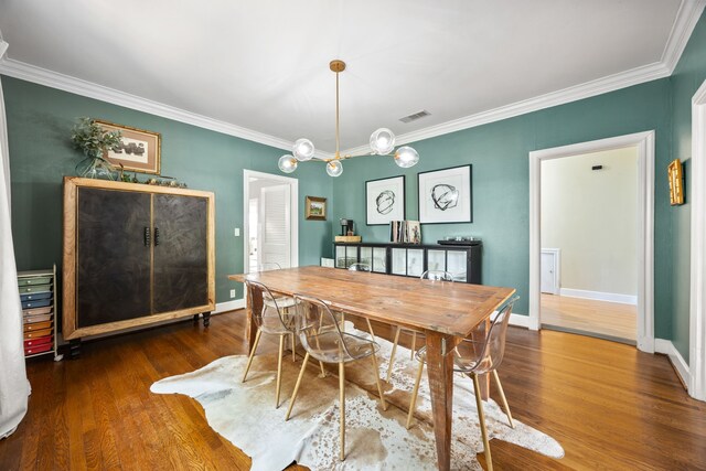 dining room featuring baseboards, ornamental molding, wood finished floors, and visible vents