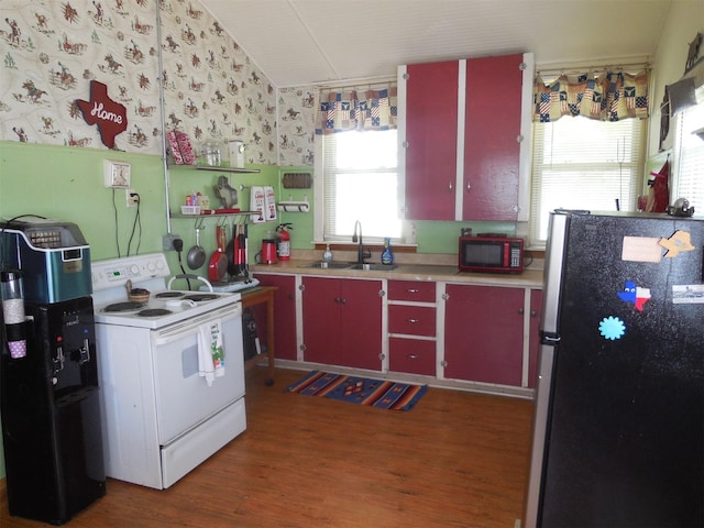 126 County Road 541, Eastland, TX 76448 - kitchen with white electric range oven, a sink, red cabinetry, freestanding refrigerator, and wood finished floors