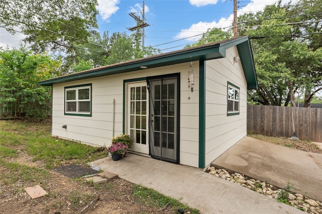 view of outbuilding featuring fence