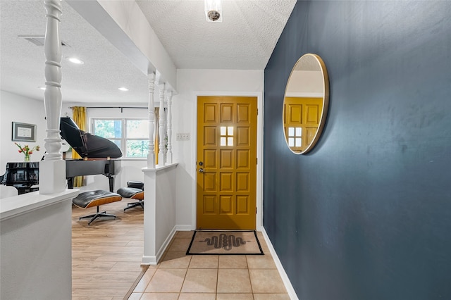 foyer featuring a textured ceiling and baseboards