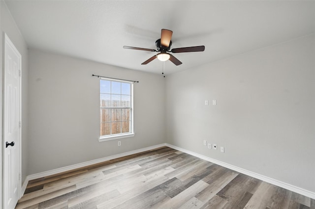 spare room featuring baseboards, a ceiling fan, and wood finished floors