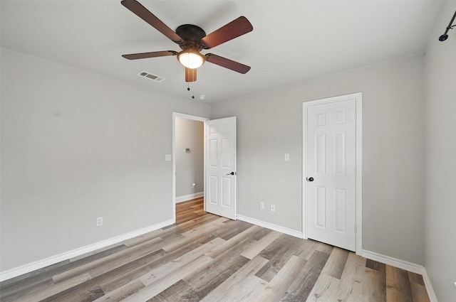 unfurnished bedroom with a ceiling fan, baseboards, visible vents, and light wood finished floors