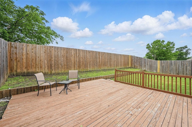 deck with a fenced backyard and a lawn