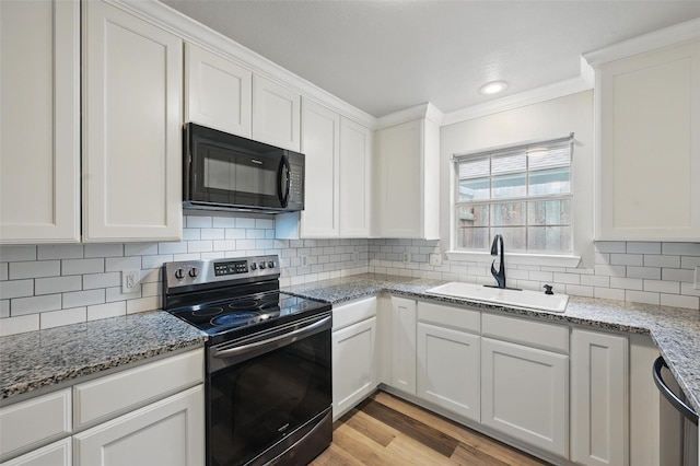 kitchen featuring crown molding, white cabinets, appliances with stainless steel finishes, a sink, and light wood finished floors