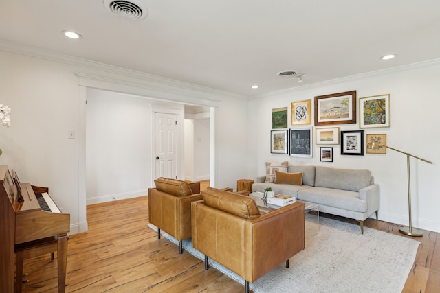 living room with crown molding, light wood-style floors, recessed lighting, baseboards, and visible vents