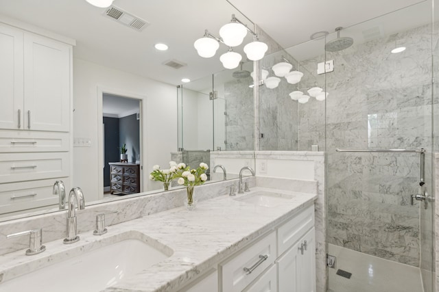 full bathroom featuring double vanity, visible vents, a sink, and a stall shower