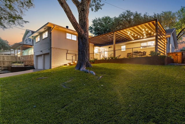 9918 Rustleleaf Dr, Dallas, TX 75238 - back of property at dusk with an attached garage, brick siding, and driveway