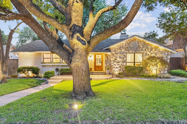 9918 Rustleleaf Dr, Dallas, TX 75238 - view of front of home featuring stone siding, a chimney, and a shingled roof