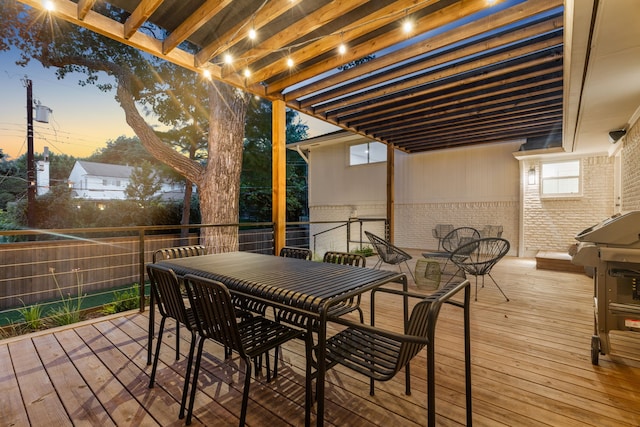 deck at dusk featuring outdoor dining area