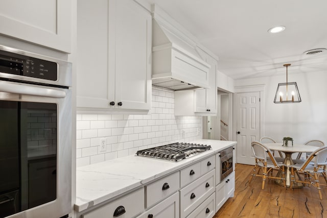9918 Rustleleaf Dr, Dallas, TX 75238 - kitchen with stainless steel appliances, white cabinetry, backsplash, recessed lighting, and light wood-style floors